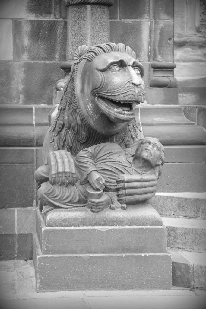 Mythical lion in from of the Dom in Bremen: cradling then figure of a man between its paws.