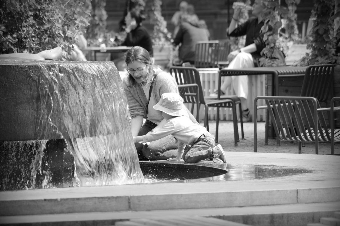 Mother and child playing at the fountain in Domplatz, Bremen.