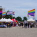 An early view of the CSD in Schwerin, with various stands displaying a variety of Pride flags.