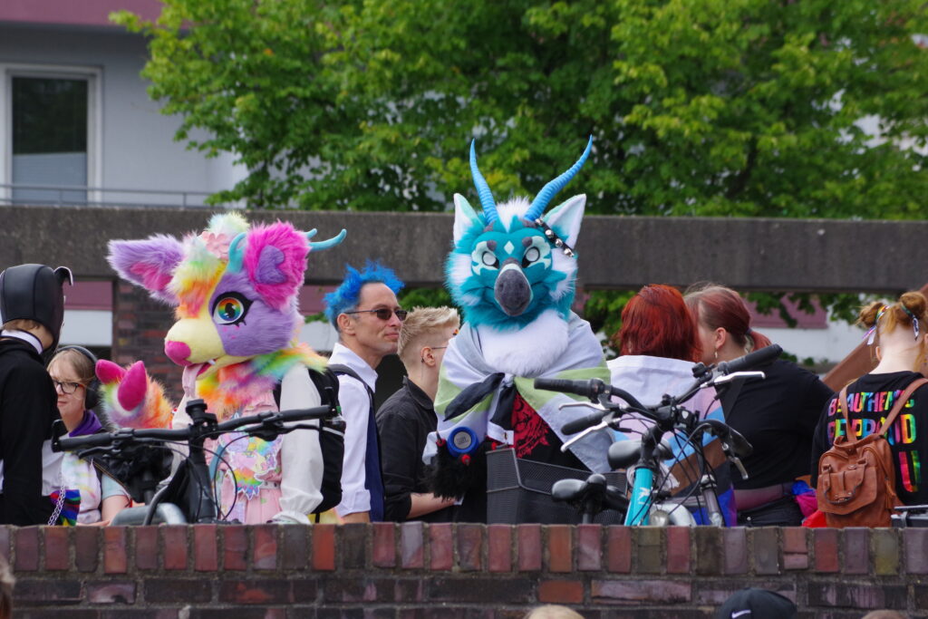 Two Furries in Bremerhaven, one a cute rainbow colour, the other a blue monster with horns.