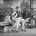 Father and daughter talking about a small dog which came near, the daughter eating a soft ice cream from a cone, the father with his arm around her. Schwerin.