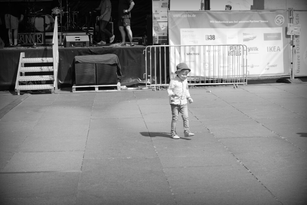 A small child dancing in the open area in front of a stage at the Braunschweig CSD 2024