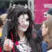 CSD Lübeck: a young person dressed in a stunning black and scarlet dress - very Japanese anime - with silver jewelry, a silver eye-pad, and carefully made up without going over the top.