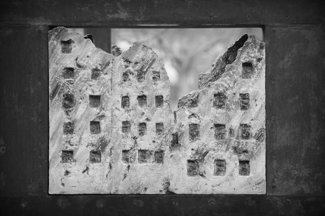 Concrete model of a destroyed city landscape within a black stone frame near Contrascarpe in Bremen, Germany.