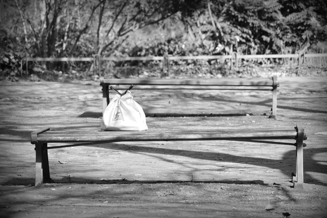 Monochrome photograph of an Aldi shopping bag left on a wooden bench in Bremen, Germany, Copyright Urban Camera.